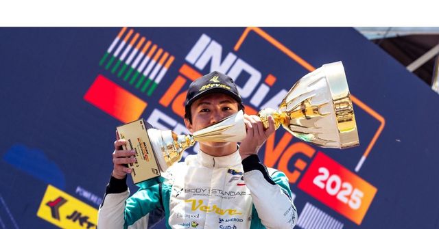 A driver lifts the winner's trophy at the Indian Racing Festival