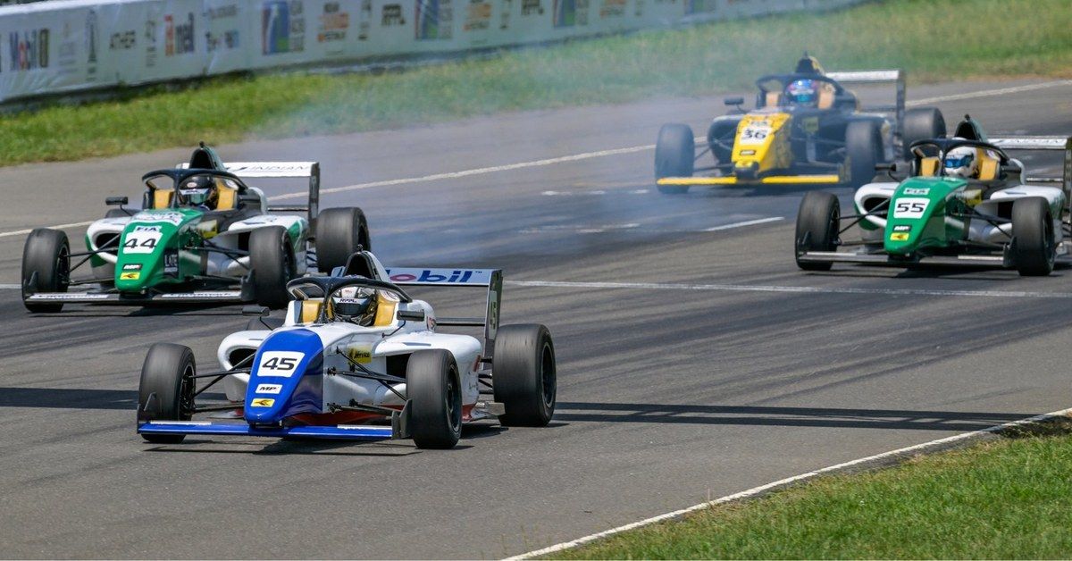 A pack of F4 Indian Championship cars fighting through a corner