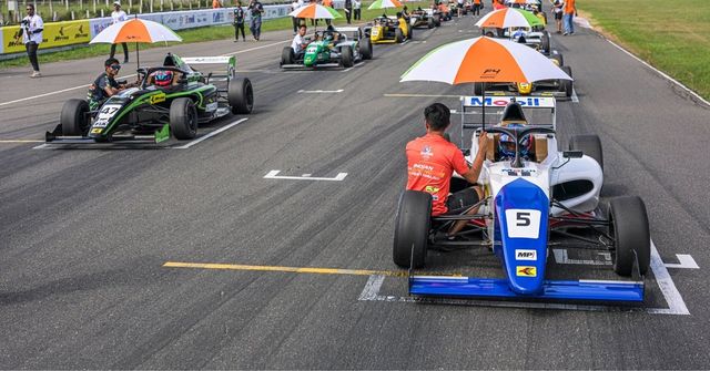 The F4 Indian Championship grid forms up under umbrellas before a race