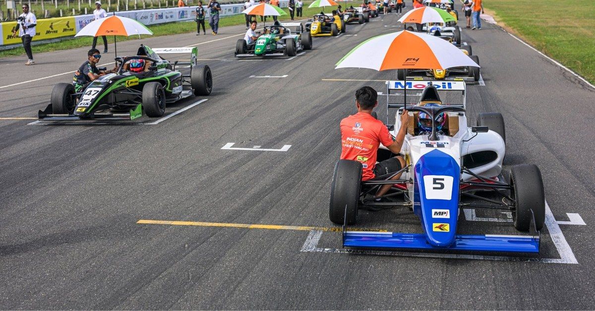 The F4 Indian Championship grid forms up under umbrellas before a race