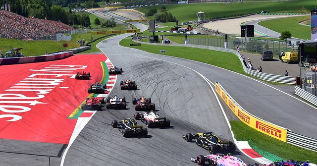 The Formula 1 field sweeping through turn one at the start of the 2018 Austrian Grand Prix