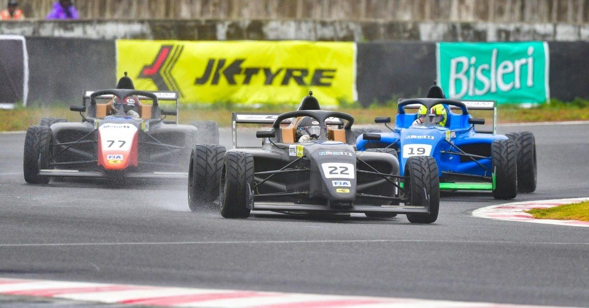 Three F4 Indian Championship cars running nose to tail through a corner